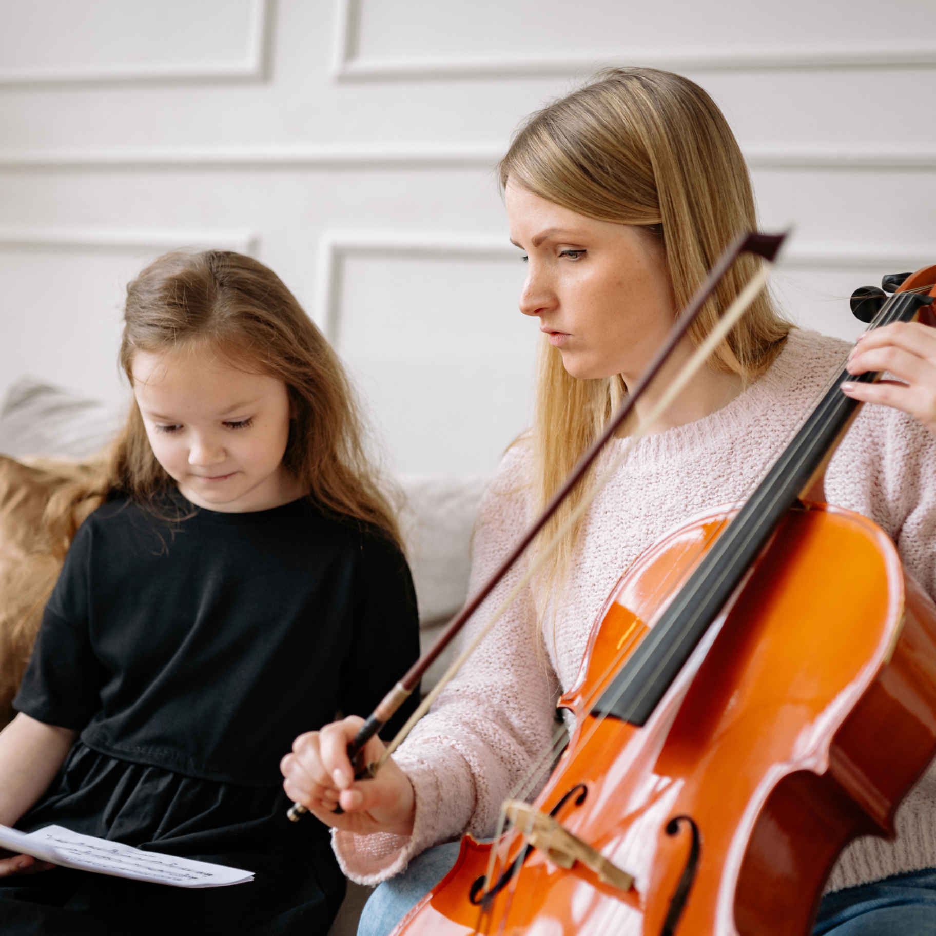 Parent and child practising together at the piano at home
