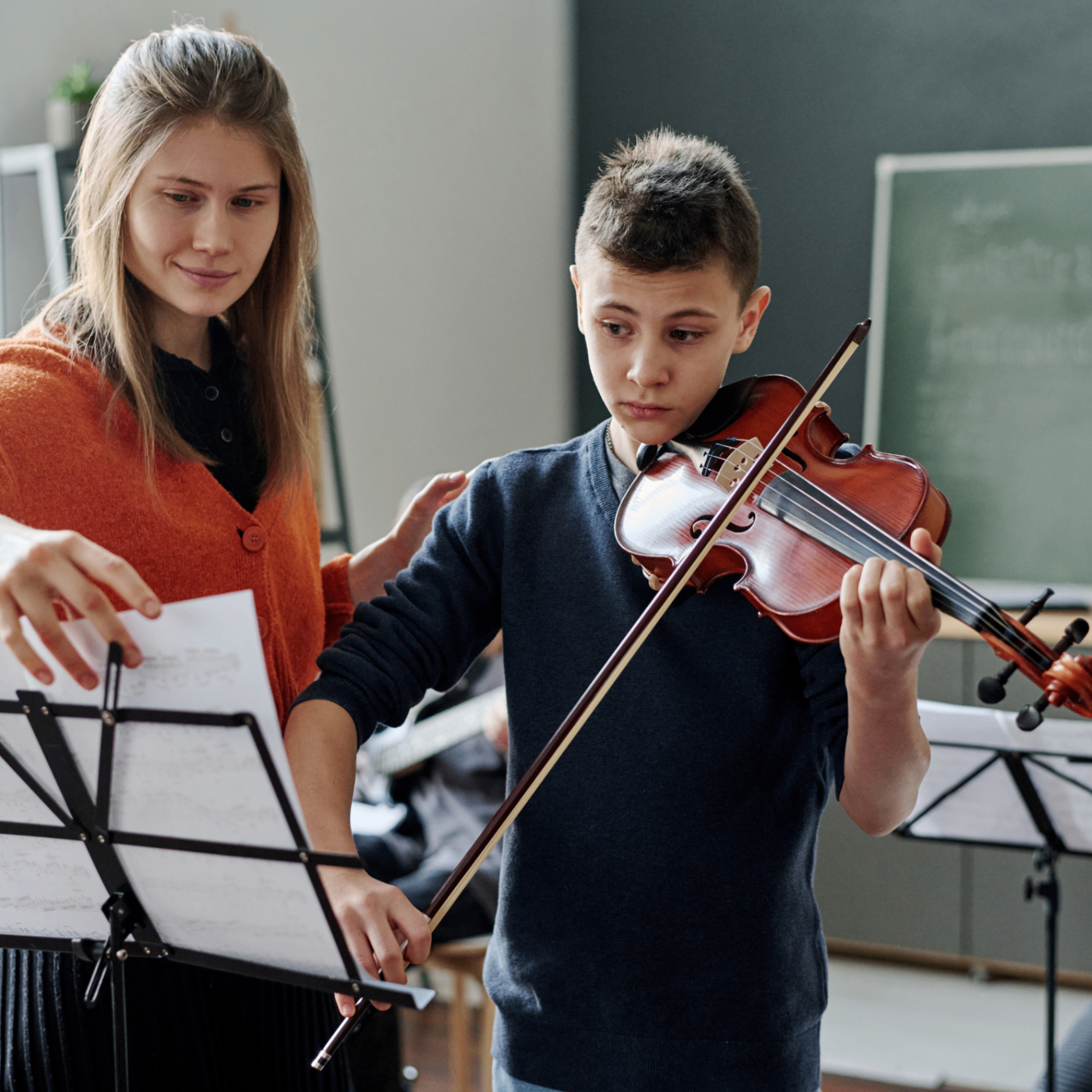 Music teacher reviewing a student's shared practice progress between lessons